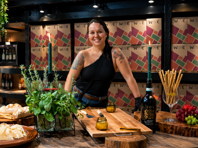 Profissional de catering ao lado de mesa de alimentos em ambiente de evento